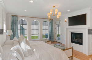 Bedroom with crown molding, a notable chandelier, access to exterior, and light wood-type flooring