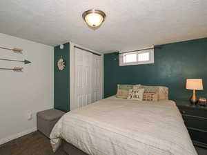 Bedroom featuring carpet flooring, a closet, and a textured ceiling