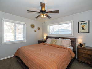 Carpeted bedroom featuring ceiling fan