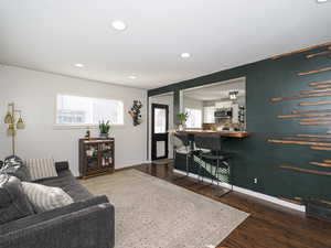 Living room with a healthy amount of sunlight and dark wood-type flooring