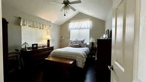 Bedroom with dark wood-type flooring, ceiling fan, and lofted ceiling