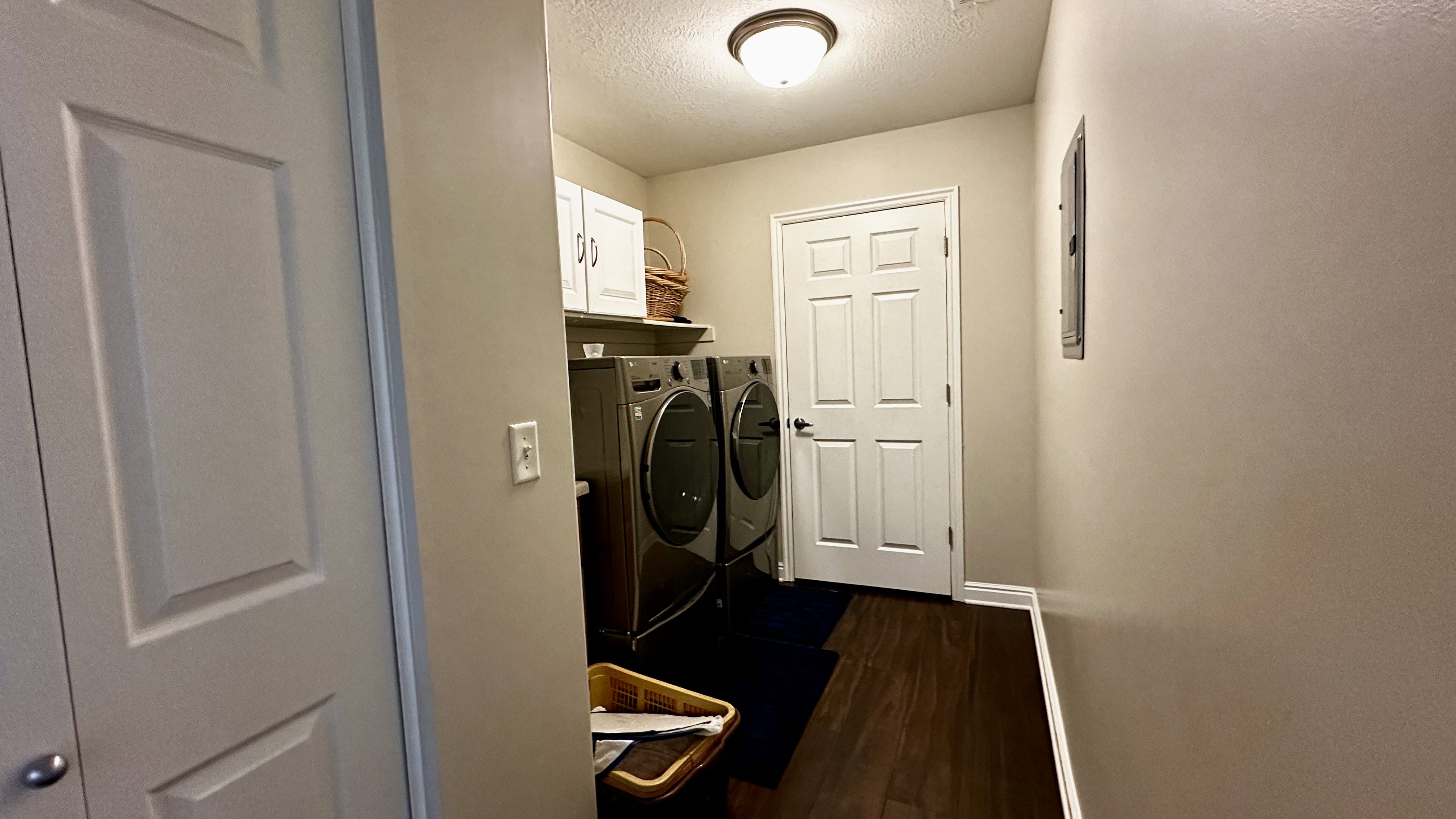 Laundry area featuring cabinets, dark hardwood / wood-style flooring, washer and dryer, and a storage closet