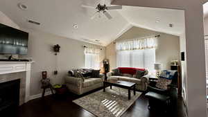 Living room with ceiling fan, a fireplace, lofted ceiling, and dark hardwood / wood-style floors