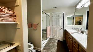 Master bathroom with a shower with door, wood-type flooring, vanity, and toilet and walk-in closet