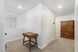 Corridor featuring light colored carpet