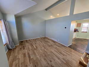 Bonus room featuring vaulted ceiling with beams and hardwood / wood-style floors