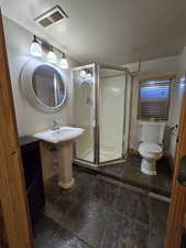 Bathroom featuring sink, toilet, and walk in shower