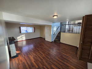 Interior space featuring dark wood-type flooring and a textured ceiling