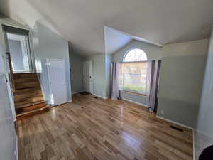 Interior space with lofted ceiling and light hardwood / wood-style floors