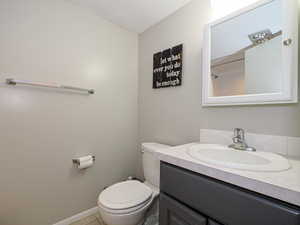 Bathroom with tile patterned floors, vanity, toilet, and a textured ceiling