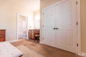 Bedroom featuring carpet, a closet, and ensuite bathroom