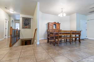 Dining space with a chandelier and light tile patterned flooring