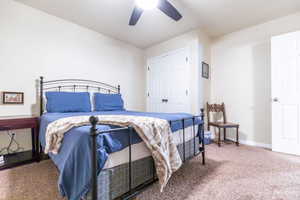 Bedroom with ceiling fan, carpet flooring, and a closet