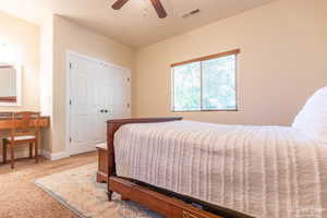 Bedroom with a closet, ceiling fan, and carpet flooring