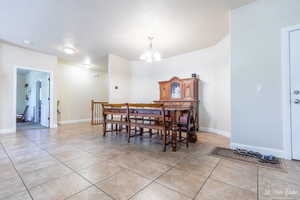 Tiled dining area featuring a notable chandelier