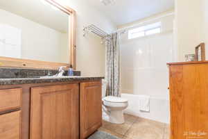 Full bathroom with vanity, toilet, tile patterned flooring, and shower / bath combo with shower curtain