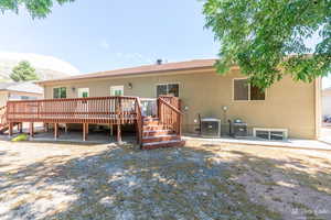 Back of house featuring central AC unit and a deck