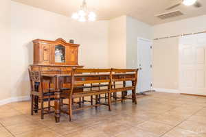 Tiled dining space featuring a notable chandelier