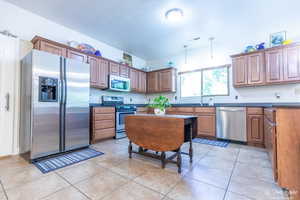 Kitchen with stainless steel appliances, sink, and light tile patterned floors