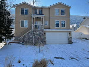 View of front of property with a mountain view and a garage