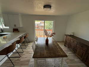 Dining room featuring light hardwood / wood-style floors and a textured ceiling