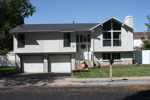 Raised ranch with a garage and a front yard