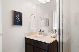 Bathroom featuring vanity and a shower with shower door