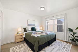 Bedroom featuring light carpet