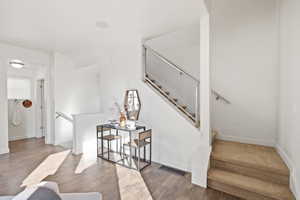 Stairs featuring hardwood / wood-style flooring