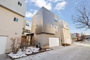 View of side of home with a garage and central air condition unit