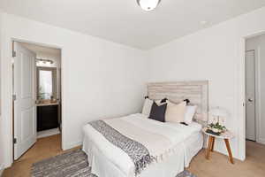 Carpeted bedroom featuring ensuite bath