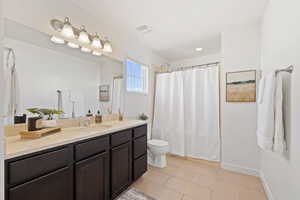 Bathroom featuring vanity, toilet, and a shower with shower curtain