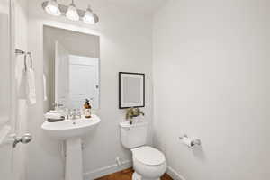 Bathroom with hardwood / wood-style floors and toilet