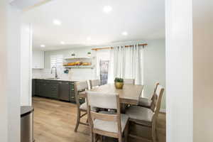 Dining area featuring farmhouse sink and light wood-type flooring