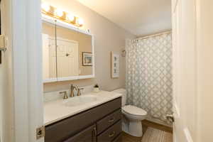 Full bathroom with vanity, toilet, and shower / bath combo with shower curtain