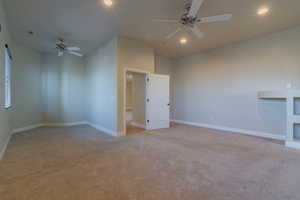 Empty room featuring ceiling fan and light colored carpet