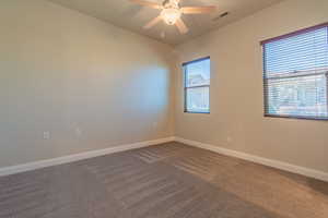 Carpeted spare room featuring ceiling fan