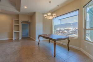 Dining room with an inviting chandelier and light tile patterned floors