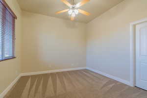 Spare room featuring carpet flooring and ceiling fan