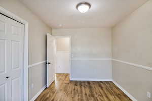 Unfurnished bedroom with hardwood / wood-style floors and a closet