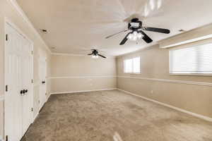 Unfurnished room featuring ceiling fan, carpet floors, and crown molding