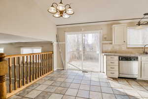 Kitchen with dishwasher, white cabinets, and plenty of natural light