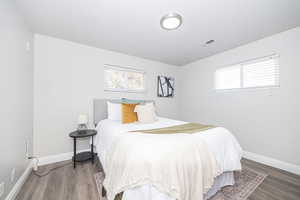 Bedroom with hardwood / wood-style floors and multiple windows