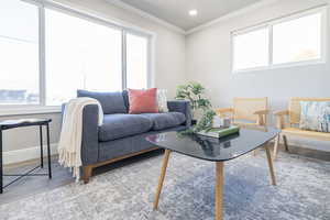 Living room with ornamental molding and hardwood / wood-style floors