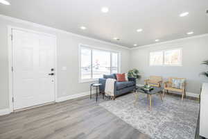 Living room featuring crown molding and light hardwood / wood-style flooring