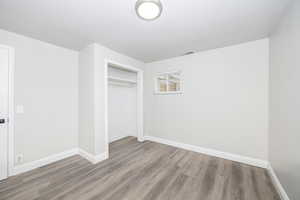 Unfurnished bedroom with hardwood / wood-style floors and a closet