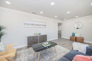 Living room featuring crown molding and light hardwood / wood-style flooring