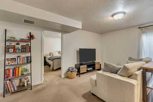 Interior space featuring a textured ceiling and carpet flooring