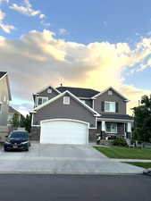 View of front facade with a garage and a lawn