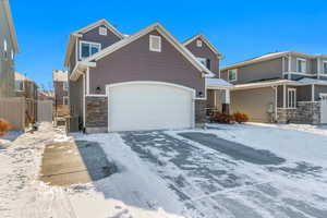 Craftsman-style home with a garage and cooling unit